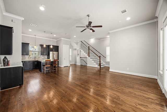 living room featuring stairs, dark wood-type flooring, visible vents, and baseboards