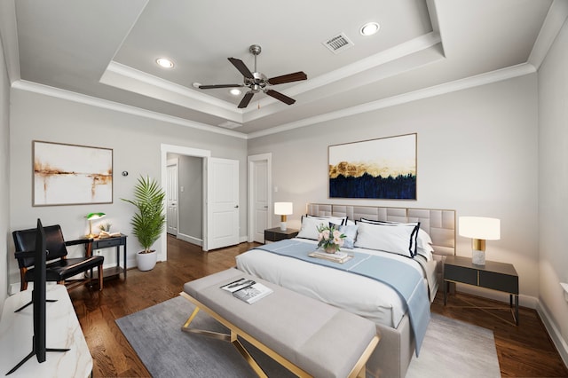 bedroom featuring visible vents, crown molding, a tray ceiling, and wood finished floors