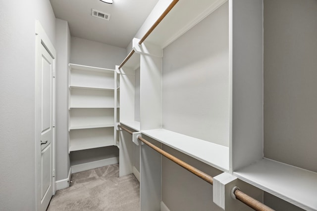 walk in closet featuring light carpet and visible vents