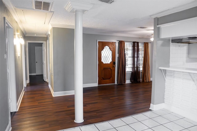 foyer with ornamental molding, visible vents, ceiling fan, and wood finished floors