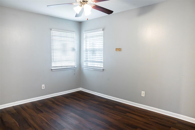 empty room with dark wood finished floors, baseboards, and ceiling fan