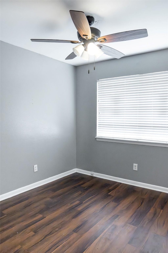 unfurnished room featuring dark wood-style floors, ceiling fan, and baseboards