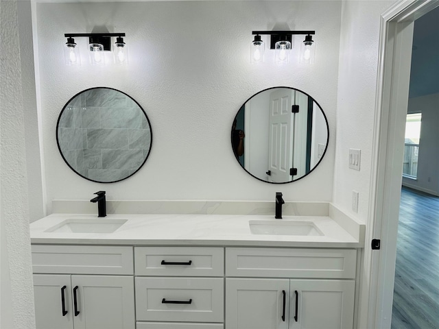 full bathroom featuring double vanity, a sink, and wood finished floors