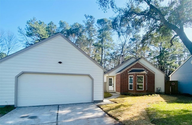 view of front of house with a chimney, a front lawn, concrete driveway, and brick siding