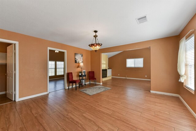 unfurnished room featuring light wood-type flooring, visible vents, and a healthy amount of sunlight