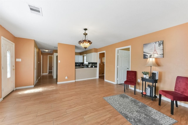 entrance foyer with baseboards, visible vents, and light wood-type flooring