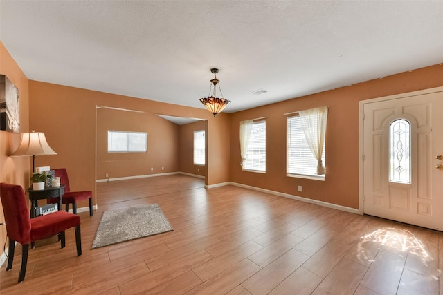 foyer featuring visible vents, baseboards, and light wood-style floors