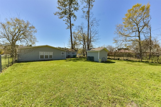 view of yard featuring an outbuilding, a storage unit, and a fenced backyard