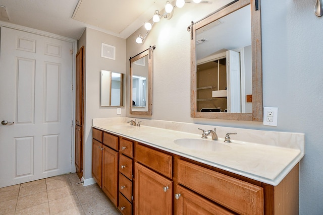 bathroom with double vanity, a sink, visible vents, and tile patterned floors