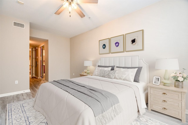 bedroom with light wood-style flooring, visible vents, and a ceiling fan