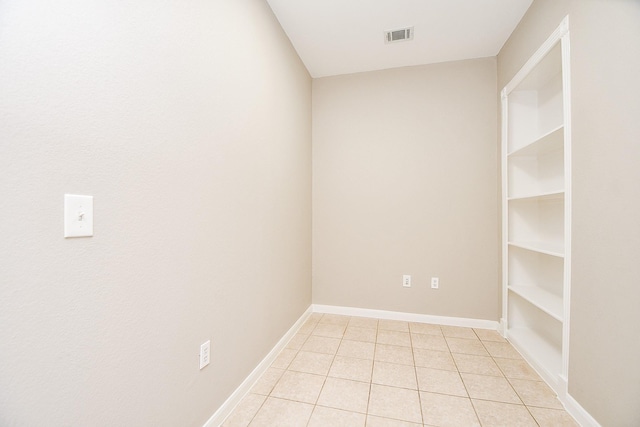 empty room featuring visible vents, baseboards, and light tile patterned floors