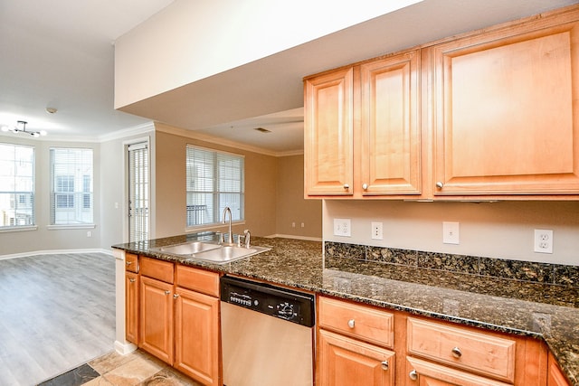 kitchen featuring dark stone counters, a sink, open floor plan, dishwasher, and crown molding