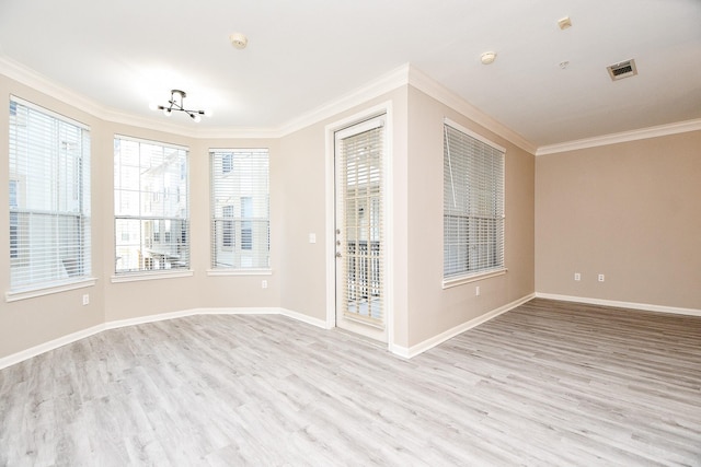 unfurnished room featuring baseboards, light wood finished floors, visible vents, and crown molding