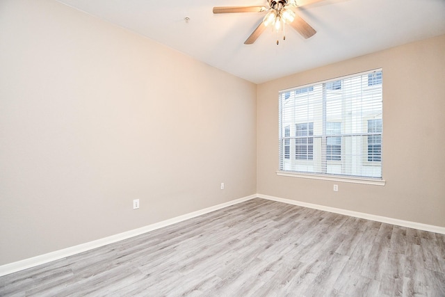 unfurnished room with a ceiling fan, baseboards, and wood finished floors