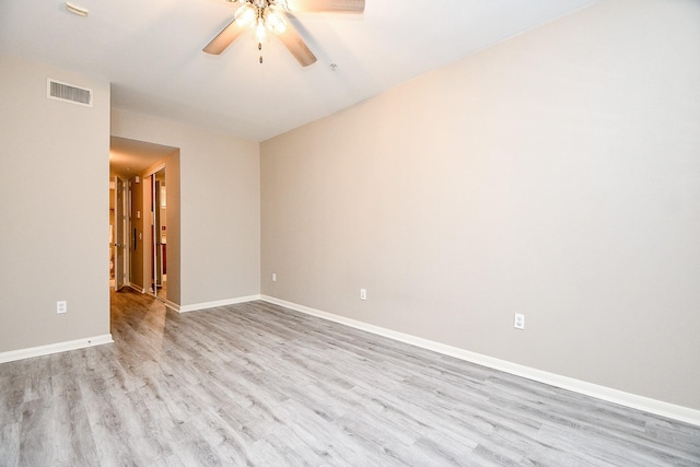 unfurnished room featuring baseboards, visible vents, ceiling fan, and wood finished floors