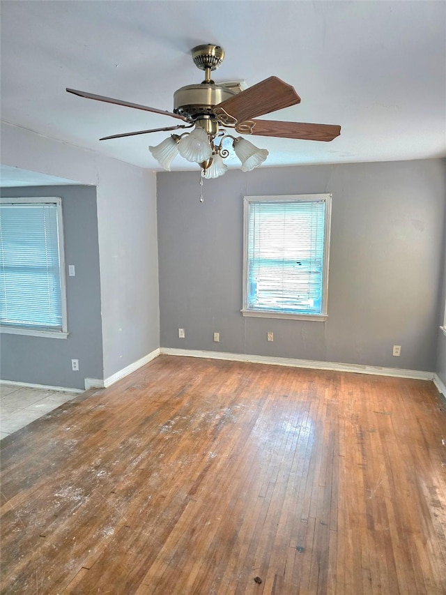 unfurnished room with wood-type flooring, baseboards, and ceiling fan