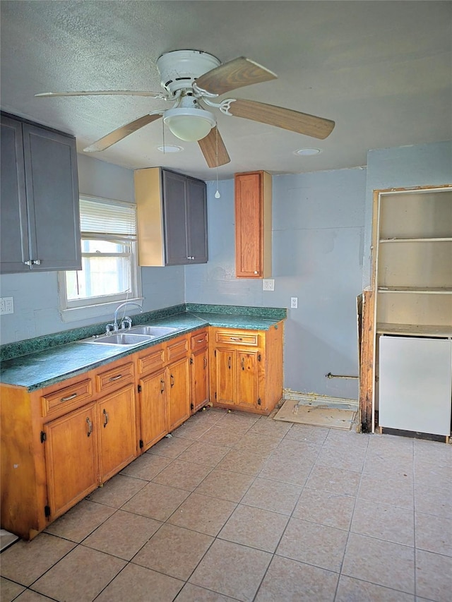 kitchen with ceiling fan, light tile patterned floors, a sink, and refrigerator