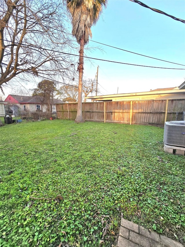 view of yard with fence and central AC unit