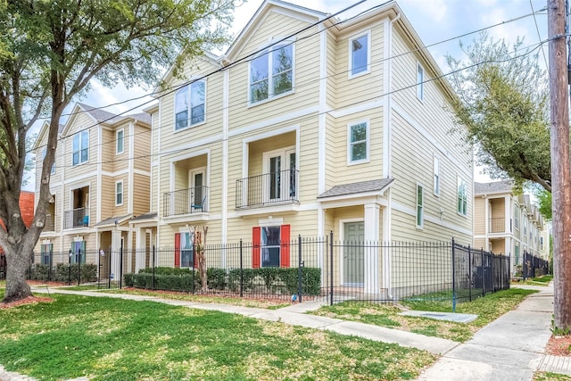 view of property with a fenced front yard, a residential view, and a front lawn