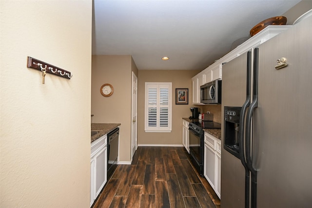 kitchen featuring dark wood-style flooring, white cabinetry, baseboards, dark stone counters, and black appliances