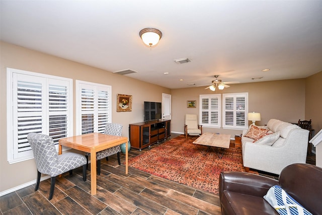 living area with wood finish floors, visible vents, and baseboards