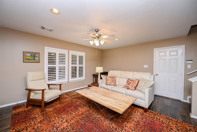 living room with dark wood-style floors, baseboards, and visible vents