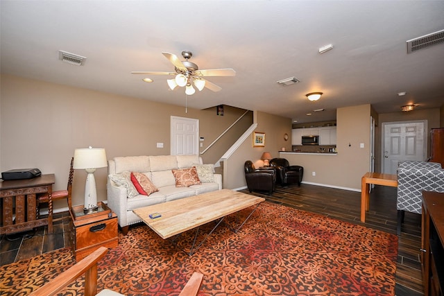 living room featuring wood finished floors, visible vents, and baseboards