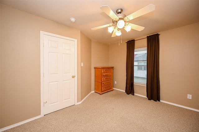 unfurnished bedroom with light carpet, ceiling fan, and baseboards