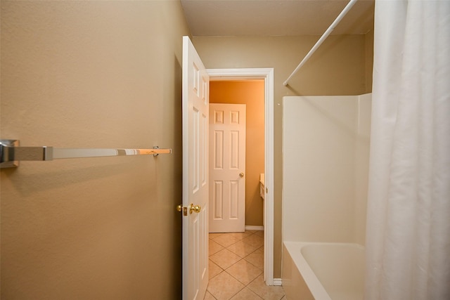 full bathroom with tile patterned flooring, baseboards, and shower / tub combo with curtain