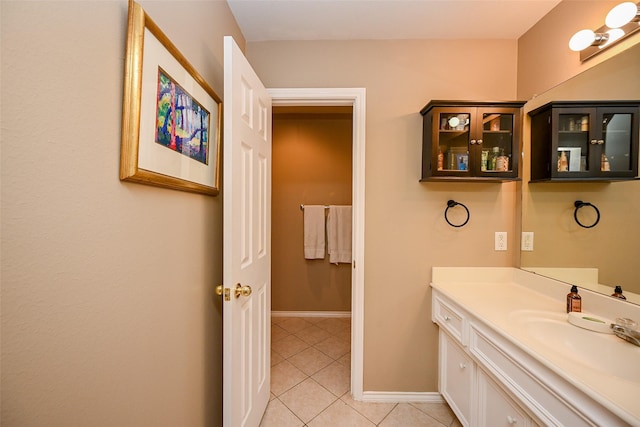 bathroom with vanity, baseboards, and tile patterned floors