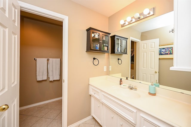 bathroom with vanity, baseboards, and tile patterned floors