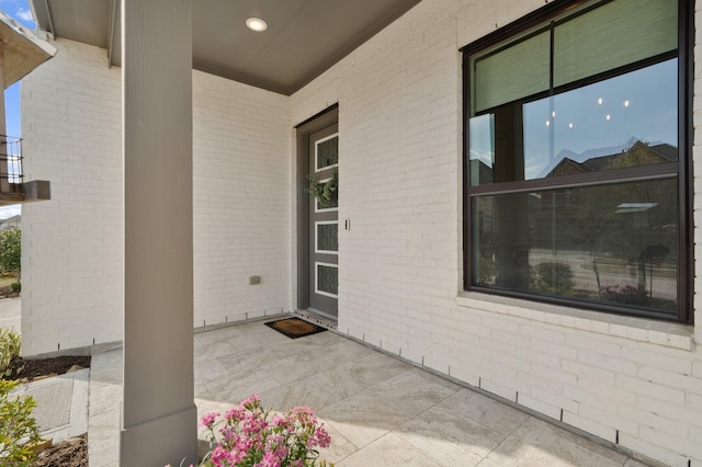 doorway to property featuring a patio area and brick siding