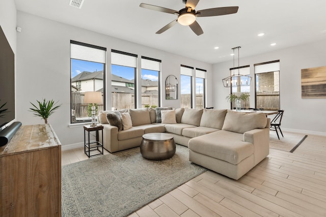 living area featuring light wood finished floors, recessed lighting, and a healthy amount of sunlight