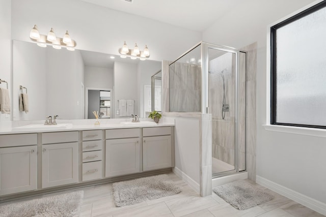 full bathroom with a stall shower, a sink, baseboards, and double vanity