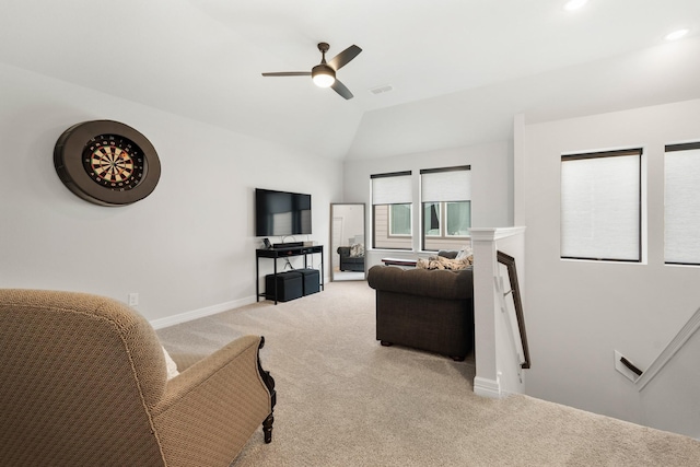 living room featuring light carpet, baseboards, visible vents, a ceiling fan, and vaulted ceiling