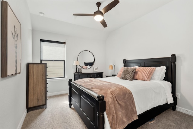 bedroom featuring baseboards, vaulted ceiling, a ceiling fan, and light colored carpet