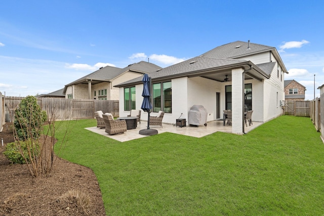 rear view of property featuring a patio area, a fenced backyard, a yard, and roof with shingles