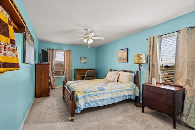 carpeted bedroom with ceiling fan and baseboards