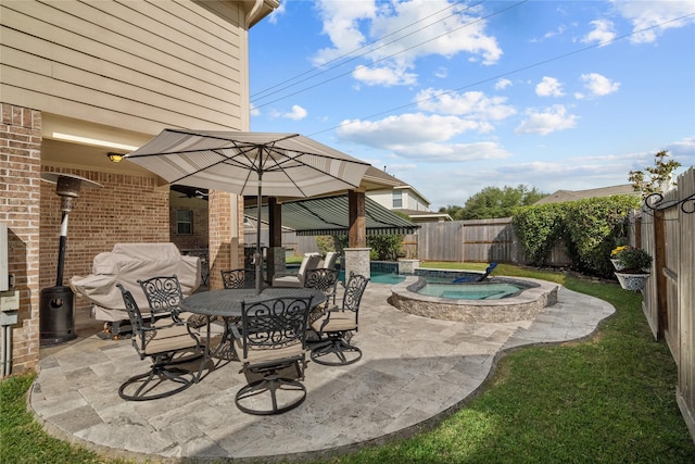 view of patio / terrace featuring a fenced backyard, a pool with connected hot tub, and outdoor dining space