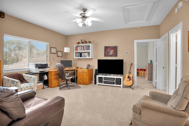 office area with attic access, a ceiling fan, and light carpet