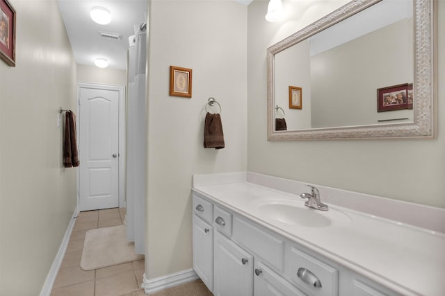 bathroom featuring vanity, baseboards, visible vents, and tile patterned flooring