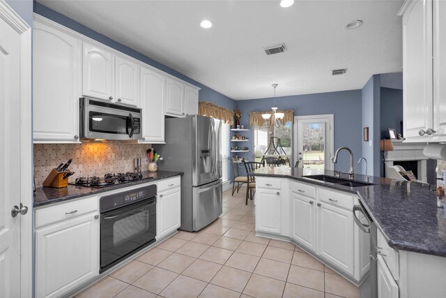 kitchen featuring visible vents, black appliances, a sink, white cabinets, and light tile patterned floors