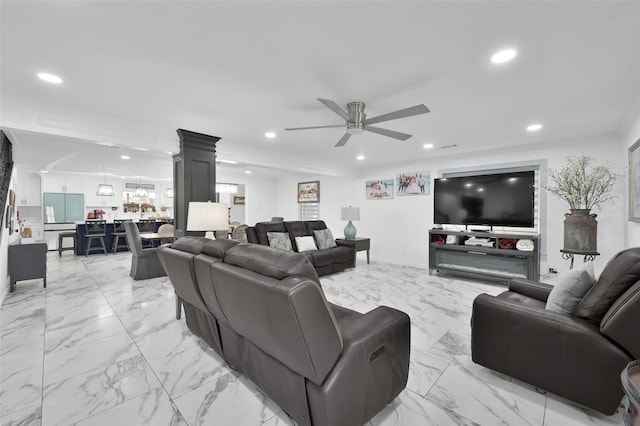 living room with a ceiling fan, recessed lighting, baseboards, and ornate columns