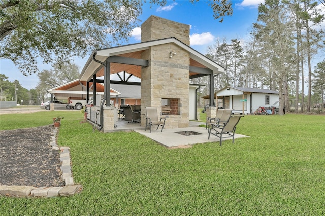 exterior space featuring a patio area, a lawn, a chimney, and a fire pit