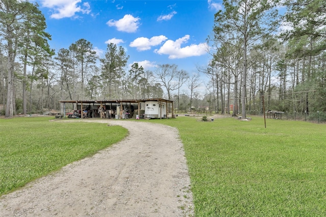 exterior space featuring an outbuilding, driveway, a yard, an outdoor structure, and a carport