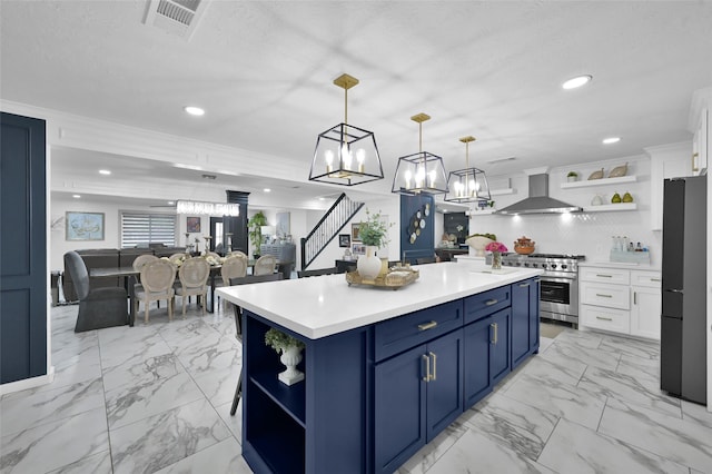 kitchen featuring open shelves, wall chimney range hood, stainless steel range, and freestanding refrigerator