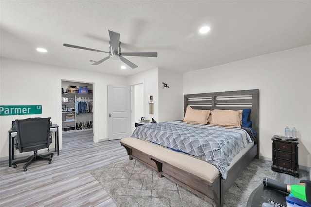 bedroom with a spacious closet, recessed lighting, ceiling fan, and wood finished floors