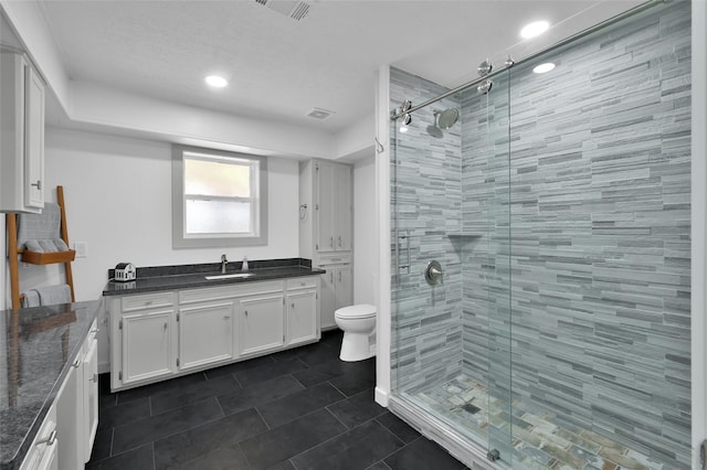 full bathroom with tile patterned floors, visible vents, a stall shower, and vanity