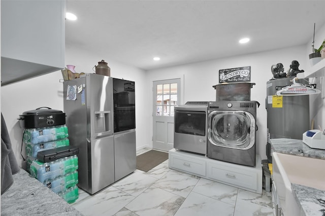 laundry room featuring marble finish floor, independent washer and dryer, water heater, recessed lighting, and laundry area