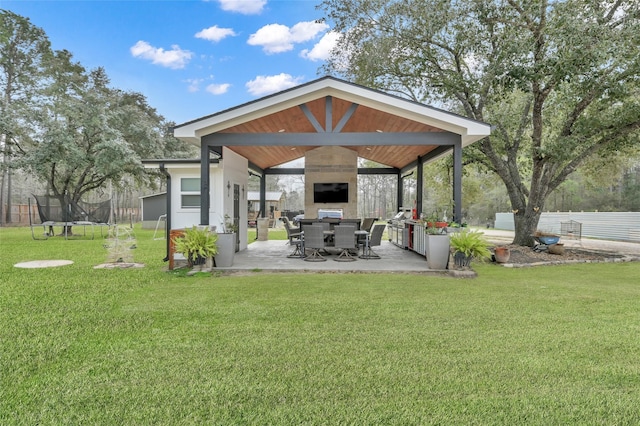 exterior space featuring a gazebo, a fireplace, a trampoline, and a patio